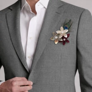 Boutonnière de mariage homme élégante avec fleurs naturelles et feuillage vert portée sur un costume chic