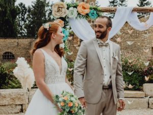 article blog couple de maries devant arche de ceremonie avec fleurs en origami