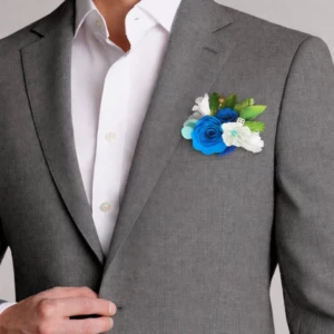 Boutonnière mariage homme bleu élégante avec fleurs délicates assortie à un costume pour cérémonie