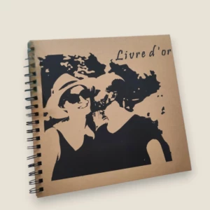 Un livre d'or de mariage carré à spirales noires avec une couverture en carton kraft marron, illustré par l'impression noire d'une photo stylisée d'un couple s'embrassant, surmontée de l'inscription cursive "Livre d'or".