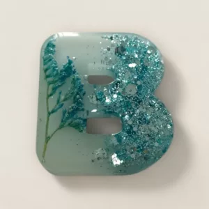 lettre resine B bleue fleurs et paillettes ideale comme porte cles ou pour marque place de mariage