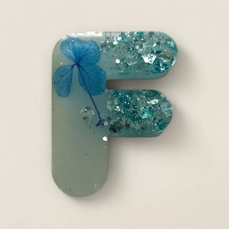 lettre resine F bleue fleurs et paillettes ideal comme porte cles ou marque place de mariage