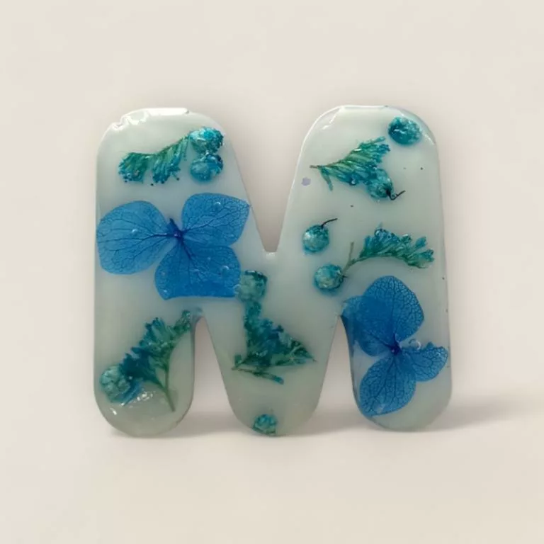 lettre resine M bleue fleurs et paillettes ideal comme porte cles ou marque place de mariage