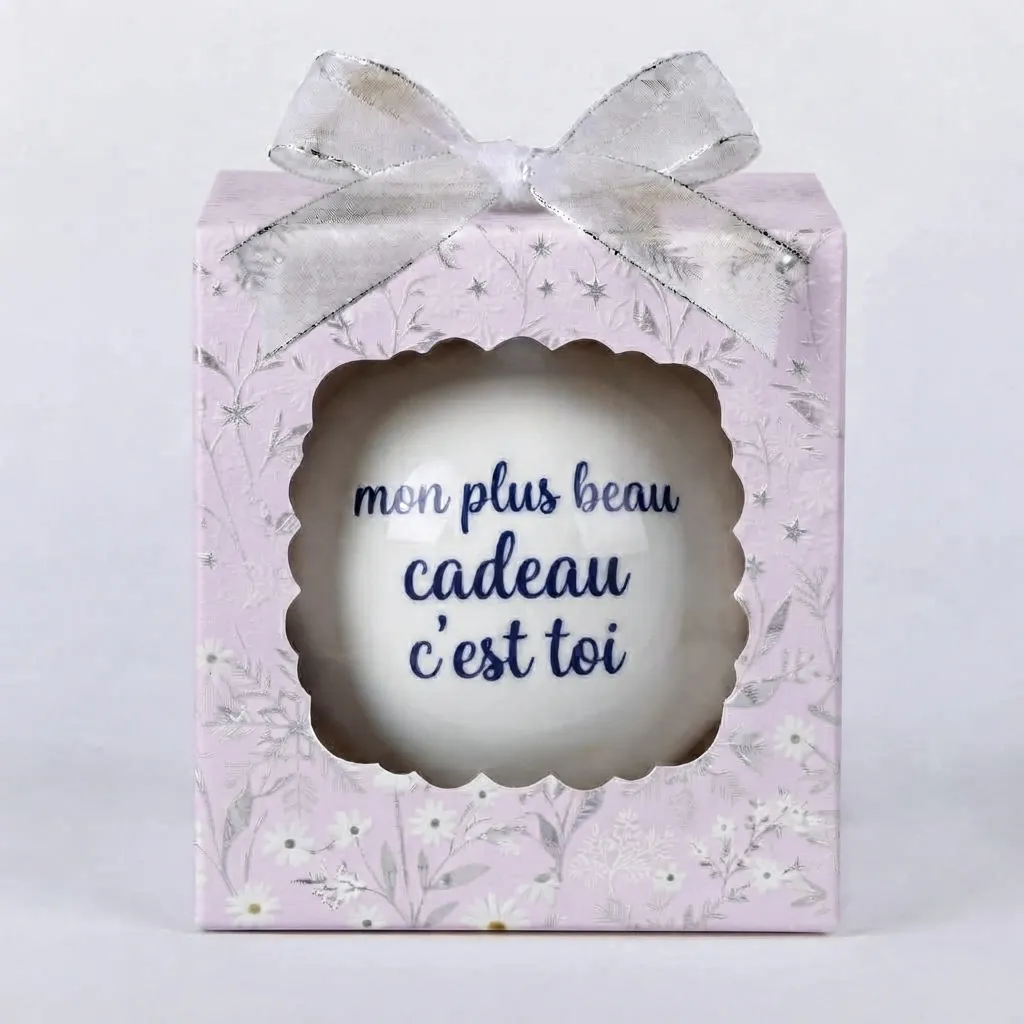 boule-de-noel-mon-plus-beau-cadeau-cest-toi Boîte cadeau violette/lilas à motifs floraux blancs et argentés avec un nœud argenté, contenant une boule de Noël blanche avec le texte bleu "mon plus beau cadeau c'est toi".