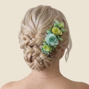 Arrangement floral pour cheveux de mariage avec roses vert menthe et foliage pastel sur tresse.