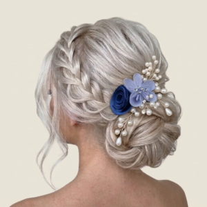 Accessoire de coiffure pour mariée avec fleurs bleu marine et blanches et pics de perles dorées.
