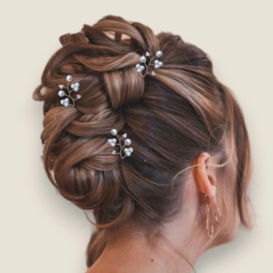 mariee portant un trio de pics a chignon en perles nacrees dorees sur chignon haut tresse