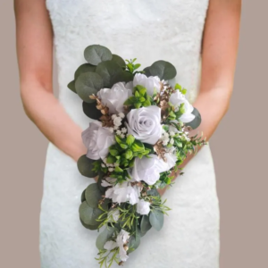 Bouquet de mariée tombant en cascade composé de roses éternelles en satin blanc, de feuillage d'eucalyptus vert foncé, de petites fleurs blanches de gypsophile et de touches de fleurs séchées dorées.