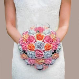 Vue centrée d'une mariée tenant un grand bouquet rond et symétrique composé de roses artificielles en papier aux teintes dégradées de rose fuchsia, corail orangé et gris perle.