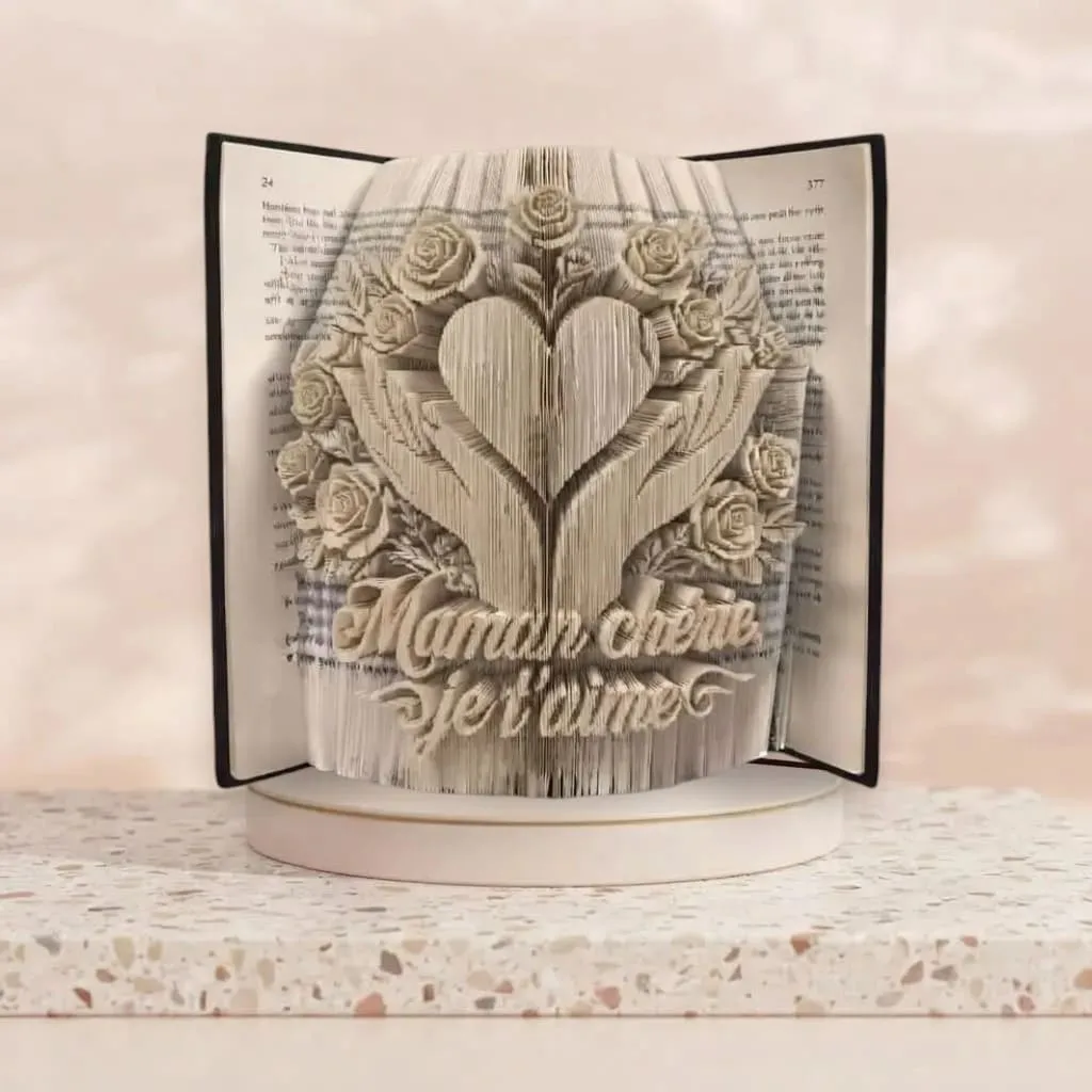 livre-plie-maman-cherie-je-taime-coeur-roses Livre plié artistique en forme de cœur entouré de roses et de mains avec l'inscription Maman chérie je t'aime, idée cadeau originale pour la fête des mères