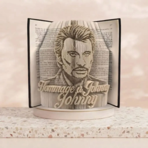 Sculpture sur livre plié représentant le portrait de Johnny Hallyday avec l'inscription Hommage à Johnny, art du pliage de pages de livre fait main