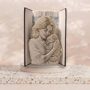 Sculpture artisanale sur livre representant une maman tenant son enfant dans ses bras avec tendresse