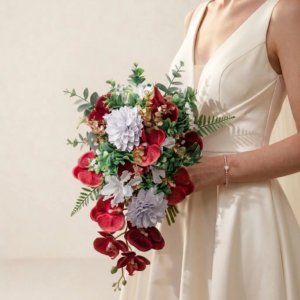 Bouquet de mariée en cascade composé d'orchidées bordeaux, fleurs en papier blanches et feuillage vert d'eucalyptus.