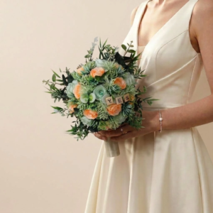 Bouquet de mariée champêtre rond vert et pêche personnalisé avec de petites lettres en bois formant le mot YES.