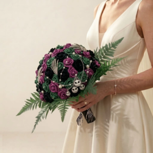 Bouquet de mariée gothique composé de roses violettes, vertes et noires agrémenté de bijoux squelettes et motifs Jack Skellington.