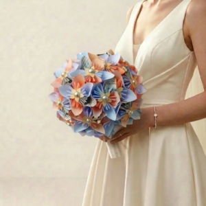 Bouquet de mariée sphérique en origami pastel bleu ciel et pêche agrémenté de perles au cœur des fleurs.