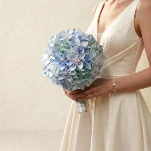 Bouquet de mariée rond en origami de papier bleu pastel et vert d'eau agrémenté de délicates perles centrales.