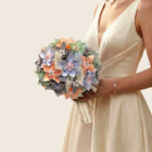 Bouquet de mariée pastel en fleurs origami pêche, bleu doux et vert menthe avec perles et ruban métallisé.