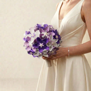 Bouquet de mariée rond en fleurs origami violet, mauve et blanc avec perles ivoire élégantes au centre.