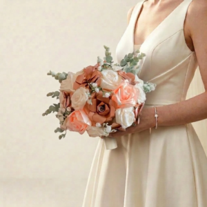 Bouquet de mariée rond aux nuances pêche, terracotta et nude agrémenté de brin d'eucalyptus vert sauge.