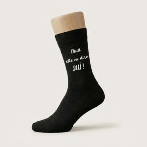 Chaussette noire pour homme avec le texte blanc humoristique "Chutt elle va dire oui !" pour mariage.