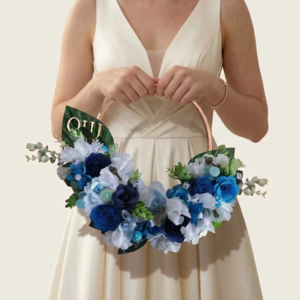 Couronne florale de mariée à cerceau métallique garnie de fleurs bleu marine, bleu ciel et blanc avec mot OUI.
